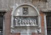 La Madonna col Bambino e San Giovanni Evangelista con i confratelli, rilievi in Campiello de la Scuola, nel Sestiere di San Polo