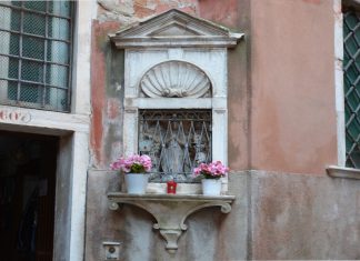 La Madonna in ascolto, statua in pietra nel tabernacolo (capitèło) in Calle de la Madona, nel Sestiere di San Marco